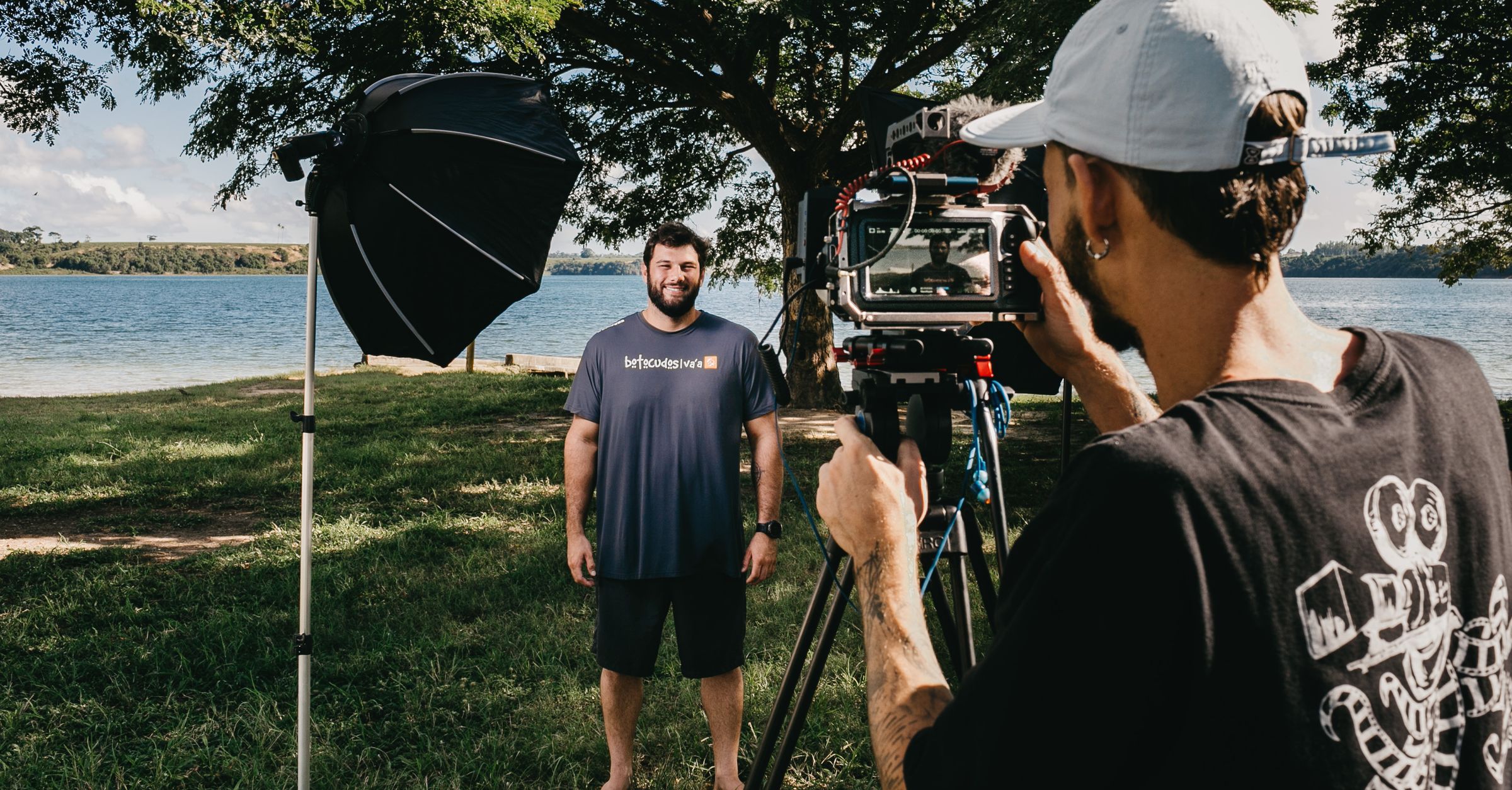 Un cadreur filme un homme au bord d’un lac.