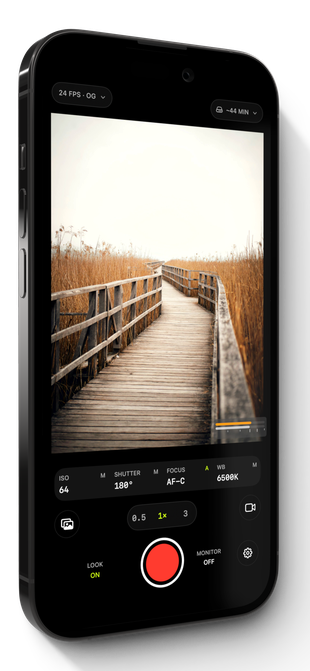 The Log Cam: RAW 4K Video Camera capture screen on an iPhone, framing a wooden boardwalk through tall reeds above a manual control row reading ISO 64, 180 degree shutter, AF-C focus and 6500K white balance.